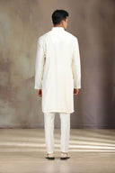 This cream silk kurta set features elegant embroidery for a sophisticated look.
