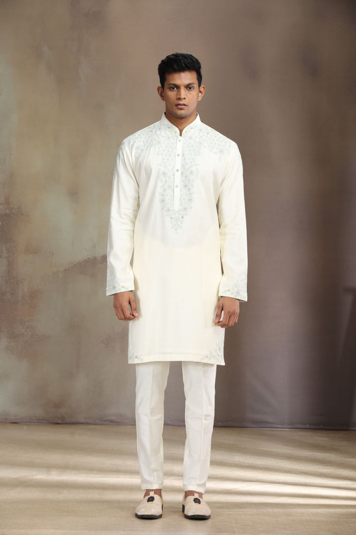 This cream silk kurta set features elegant embroidery for a sophisticated look.