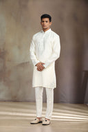 This cream silk kurta set features elegant embroidery for a sophisticated look.