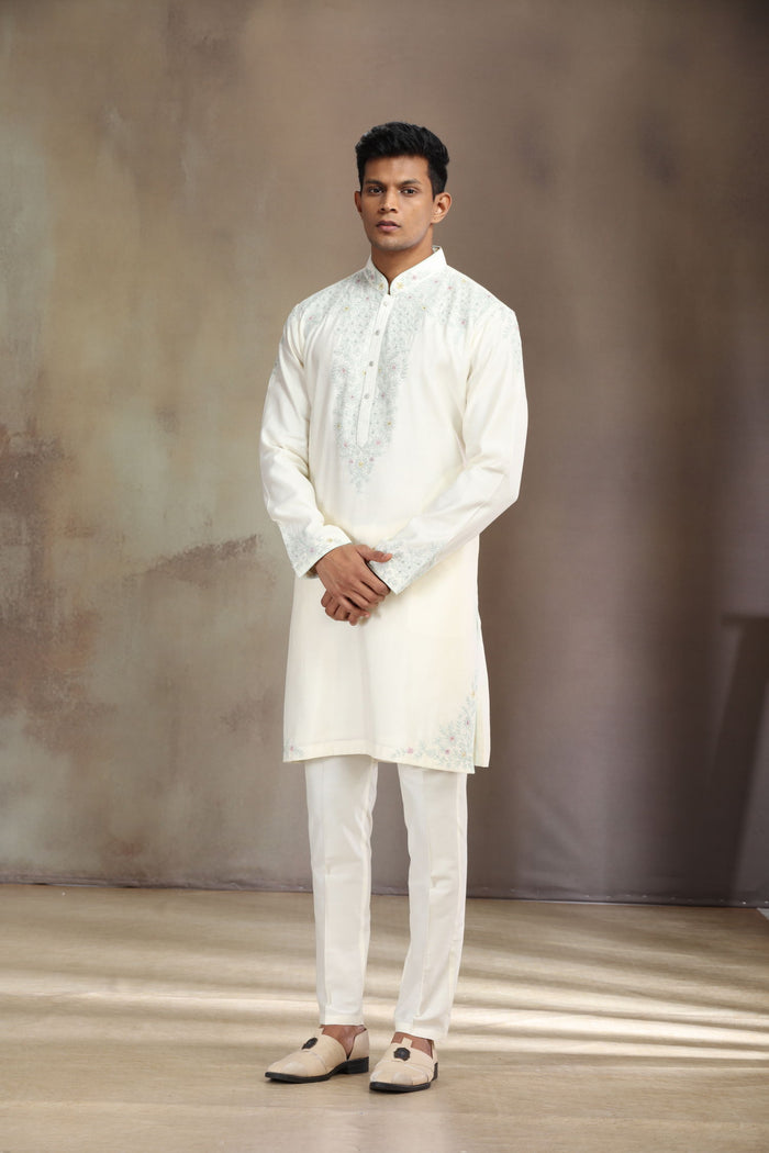 This cream silk kurta set features elegant embroidery for a sophisticated look.