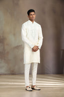 This cream silk kurta set features elegant embroidery for a sophisticated look.