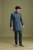 Close-up of hand embroidery and metal embellishment on rama green satin linen kurta