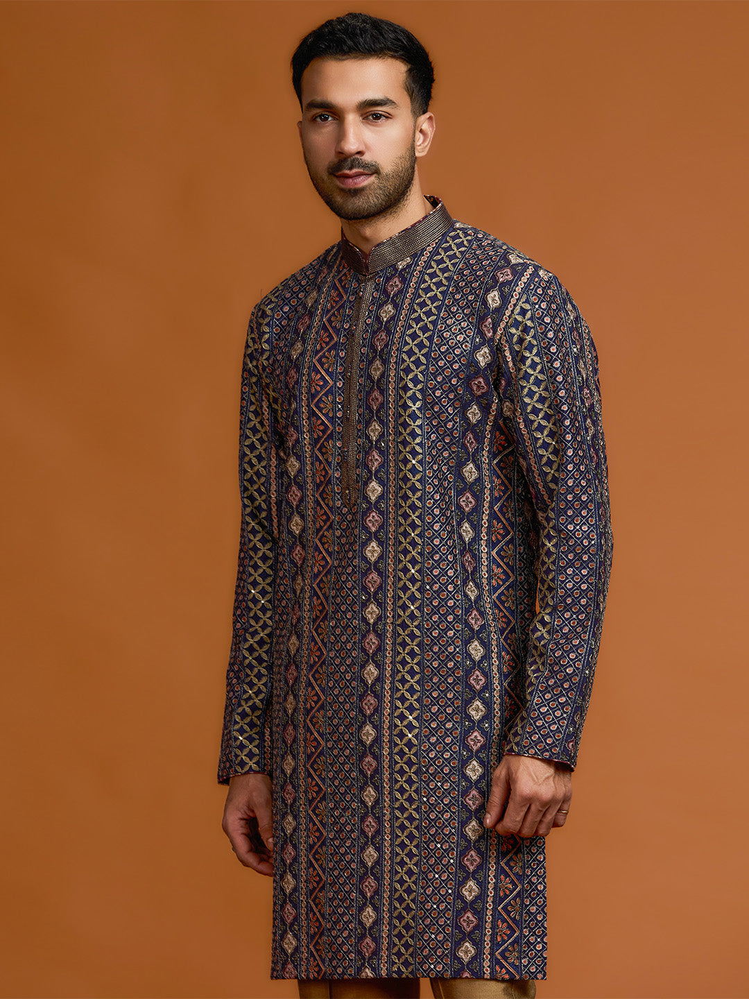 Navy blue kurta with architectural print, dense tonal threadwork, and subtle shimmer, paired with antique gold Aligarh pants. - KORANM