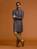 Navy blue kurta with architectural print, dense tonal threadwork, and subtle shimmer, paired with antique gold Aligarh pants.
