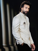 Close-up of textured Matka silk Bandhgala coat with brooch – Kora by Nilesh Mitesh